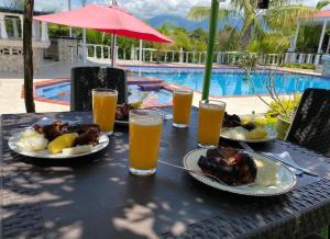 uma mesa com pratos de comida e copos de cerveja em Finca Hotel villa el Ocaso Rivera Huila em Riverita