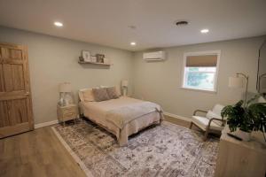 a bedroom with a bed and a chair and a window at The Edamame House 