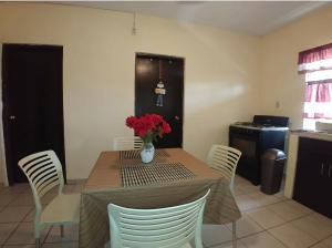 una mesa de comedor con un jarrón de flores. en MyM Departamentos, en Matamoros