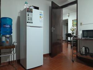 einen weißen Kühlschrank in einem Zimmer mit einem Tisch in der Unterkunft OBhouse Apartment, para sentirse como en casa! in Asunción