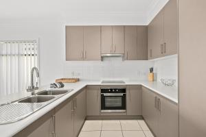 a kitchen with white cabinets and a sink at Sea Spray - Aldinga Beach - C21 SouthCoast Holidays in Aldinga Beach
