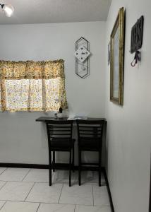 a table and two chairs in a room with a window at Denyse Home Cottage in Saint Johnʼs