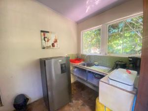 a small kitchen with a refrigerator and a sink at Finca Cristal con Piscina Room Perezoso in Talamanca