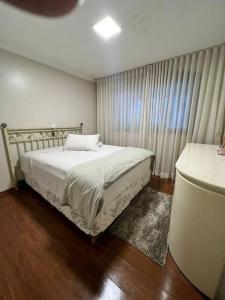 a bedroom with a bed and a window with curtains at Casa chácara de lazer altos do pequeno vale in Caxias do Sul +46 photos