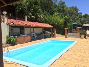 a swimming pool in front of a house at Casa chácara de lazer altos do pequeno vale in Caxias do Sul