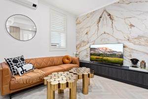 a living room with a couch and a tv at Central 2-Bed Terrace House by the Harbour in Sydney