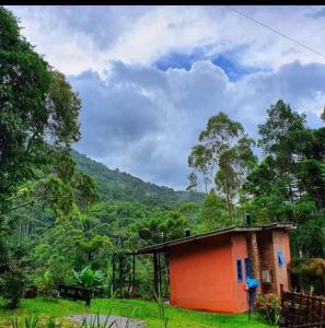 uma pequena casa num campo com montanhas ao fundo em Chalé LN em Gonçalves