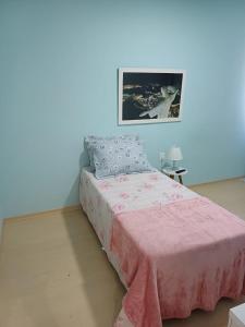 una camera con un letto e una coperta rosa di Suíte Palace a Rio de Janeiro