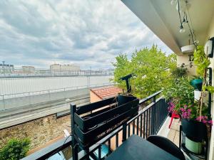 einen Balkon mit Pflanzen und Blick auf das Wasser in der Unterkunft Confort au cœur des Puces PARIS Appartement modern in Saint-Ouen