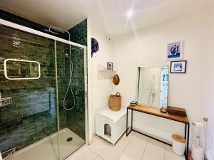 a bathroom with a glass shower and a toilet at Confort au cœur des Puces PARIS Appartement modern in Saint-Ouen