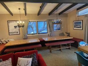 sala de estar con mesa grande y bancos en Nutcracker Ski Club en Mount Buller