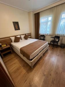 a bedroom with a large bed and wooden floors at Aycan Sultan Apart Hotel in Istanbul