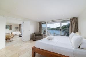 a bedroom with a large white bed and a living room at Mariner Apartments in Port Vila