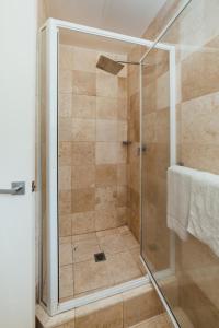 a shower with a glass door in a bathroom at Mariner Apartments in Port Vila