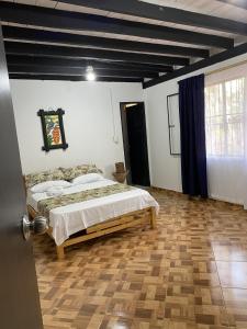 1 dormitorio con 1 cama y suelo de madera en ACORI WUHU, en Mitú