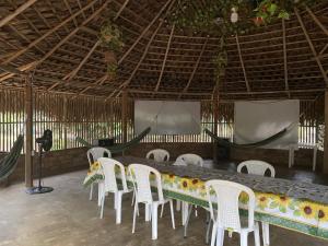 jadalnia z długim stołem i białymi krzesłami w obiekcie ACORI WUHU w mieście Mitú