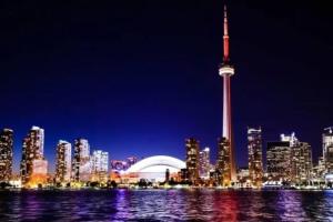 a city skyline with the cn tower at night at Superb Spacious Loft Old Toronto near Distillery District in Toronto