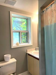 a bathroom with a window and a toilet and a sink at Superb Spacious Loft Old Toronto near Distillery District in Toronto