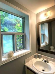 a bathroom with a sink and two windows at Superb Spacious Loft Old Toronto near Distillery District in Toronto