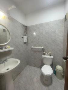 a bathroom with a white toilet and a sink at Contry Mar Caraballeda in Caraballeda