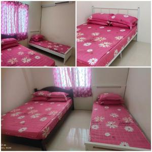 a bedroom with two beds with pink covers at Homestay Lumut in Lumut
