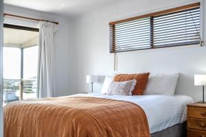 a bedroom with a large bed and a window at Bicheno Blue Horizon in Bicheno
