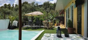 a backyard with a swimming pool and an umbrella at El refugio los portales in Arucas