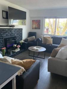 ein Wohnzimmer mit einem Sofa und einem Kamin in der Unterkunft 4 bed upper level Kits home in Vancouver