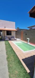 una casa con una pista de tenis verde en el patio en Casa de Praia com Piscina, en Camaçari