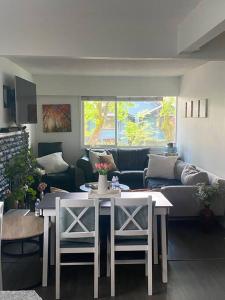 a living room with a couch and a table and chairs at 4 bedroom shared home and bath on a quiet tree lined street in Vancouver