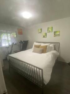 ein Schlafzimmer mit einem großen Bett mit weißer Bettwäsche und Kissen in der Unterkunft 4 bed upper level Kits home in Vancouver