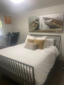 ein Bett mit weißer Bettwäsche und Kissen in einem Schlafzimmer in der Unterkunft 4 bed upper level Kits home in Vancouver