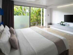 a bedroom with a large bed and a large window at Explorar Koh Phangan - Adults Only Resort and Spa in Haad Rin