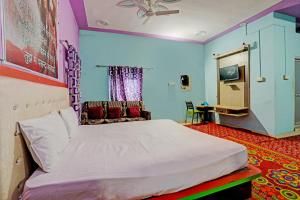 1 dormitorio con 1 cama y TV. en OYO Riddhi Siddhi Hotel And Marriage Garden 