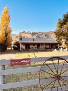 una casa colonica con una staccionata bianca e un cartello di Hillview Cottage a Mansfied