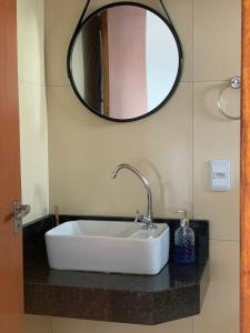 a white sink in a bathroom with a mirror at Chalé Aconchego da Serra in Serra de São Bento