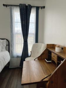 a bedroom with a desk and a chair and a bed at Bugge Room 203, Hyland Hotel in Palmer