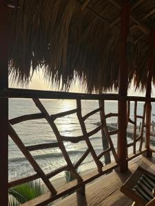 een uitzicht op de oceaan vanuit een strohut bij Cabaña Punta Coral in Rincón