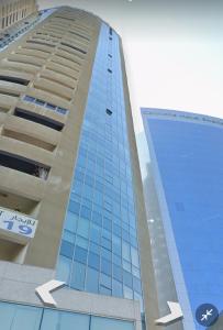a tall blue building with arrows pointing up at Luxury Corniche Apartment in Sharjah
