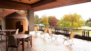 eine Terrasse mit Tischen, Stühlen und einem Pavillon in der Unterkunft LivingAnywhere Commons Aizu Bandai Mixed Dormitory - Vacation STAY 14957v in Inawashiro