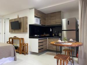 Una pequeña cocina con una mesa y un refrigerador. en Bela Hospedagem - #Unity Flats Cabo Branco, en João Pessoa