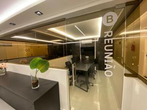 una oficina con una pared de cristal con una mesa y una planta en Bela Hospedagem - #Unity Flats Cabo Branco, en João Pessoa 68 fotos más