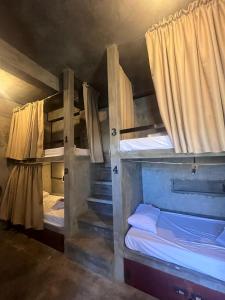 San IsidroにあるKatre Siargao - SELF CHECK-IN Hostelのカーテン付きの客室で、二段ベッド2台が備わります。