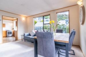 una sala da pranzo con tavolo e sedie di Marina Nest - Timeless & Majestic Kiwi Family Bach - Beautiful Lake Views a Queenstown
