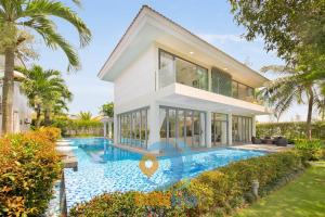 a house with a swimming pool in front of a house at Diamond Beach Villa Da Nang in Danang