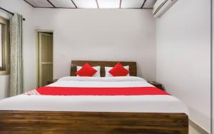 a bedroom with a large bed with red pillows at Ram Homestay in Kangra
