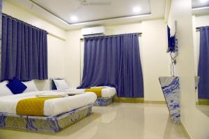 - 2 lits dans une chambre avec des rideaux violets dans l'établissement Hotel Edition, Mumbai, à Mumbai