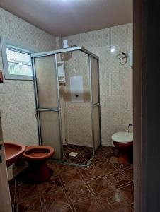 La salle de bains est pourvue d'une douche, de toilettes et d'un lavabo. dans l'établissement Pousada central Vino e Leta, à Grão Pará