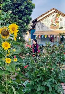 een vrouw in een tuin met zonnebloemen bij Vietnam Phuot Real Home in Kon Tum (2)