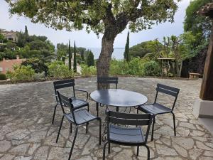a table and chairs with a table and a tree at Maison Les Issambres, 3 pièces, 6 personnes - FR-1-768-79 in Saint-Peïre-sur-Mer